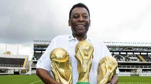 Pele pictured holding his three world cup trophies (1958,1962,1970). 

