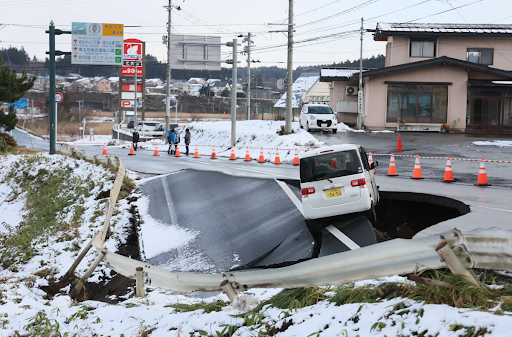 “A vehicle teetered on a collapsed road in Tohoku Town off the coast of northern Japan.” (NYT)